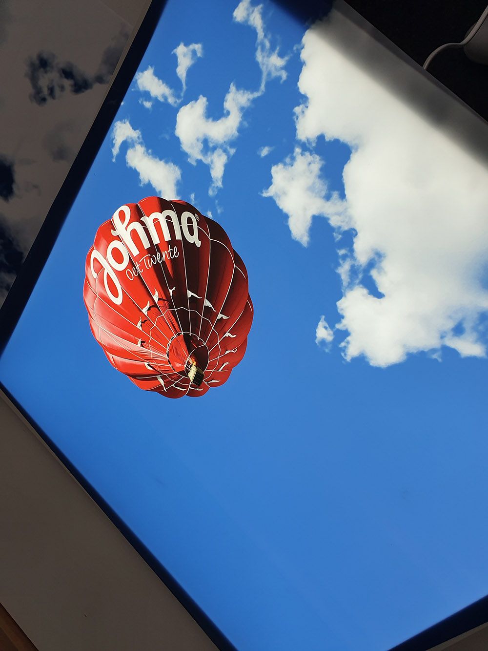 Wolkenplafond met luchtballon in Johma-logo